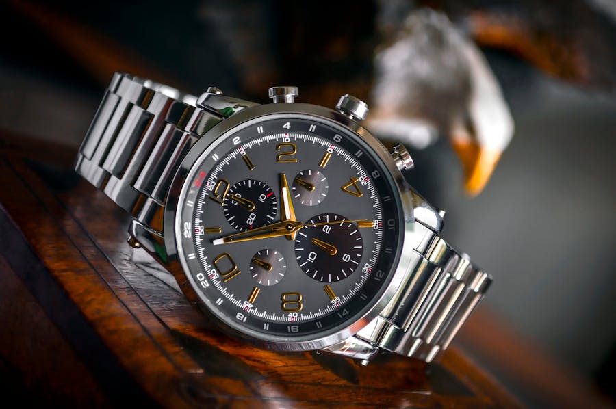 Poignet féminin portant une montre et bracelet sur fond de feuillage vert — montre femme élégante