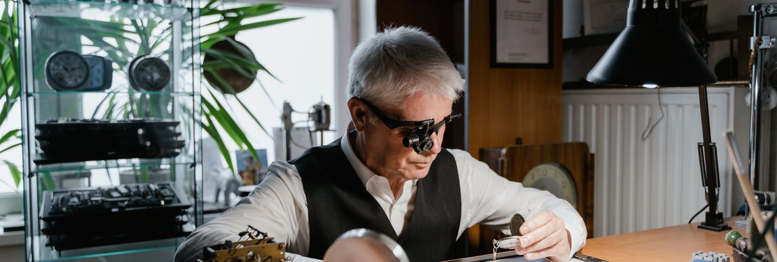 Horloger au travail dans son atelier, loupe à l'oeil