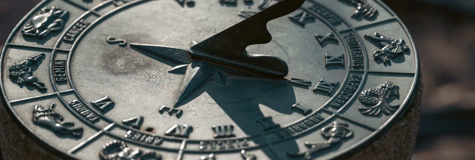 Cadran solaire ancien en gros plan, l'ombre du gnomon traversant les chiffres romains