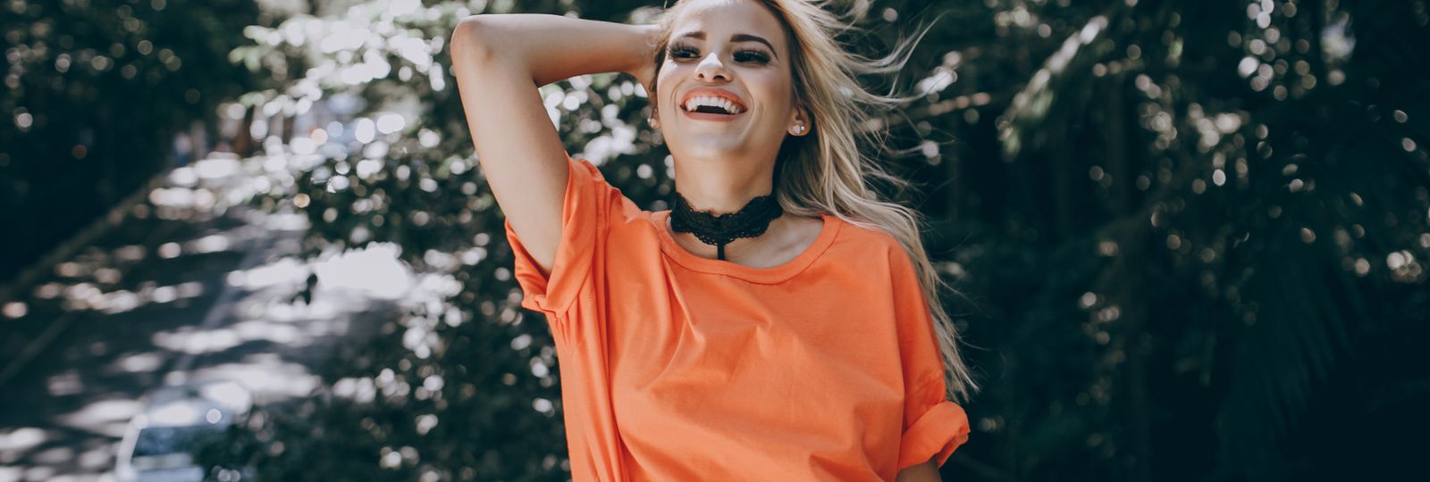 Montre femme été 2026 — jeune femme souriante au soleil, tenue estivale colorée